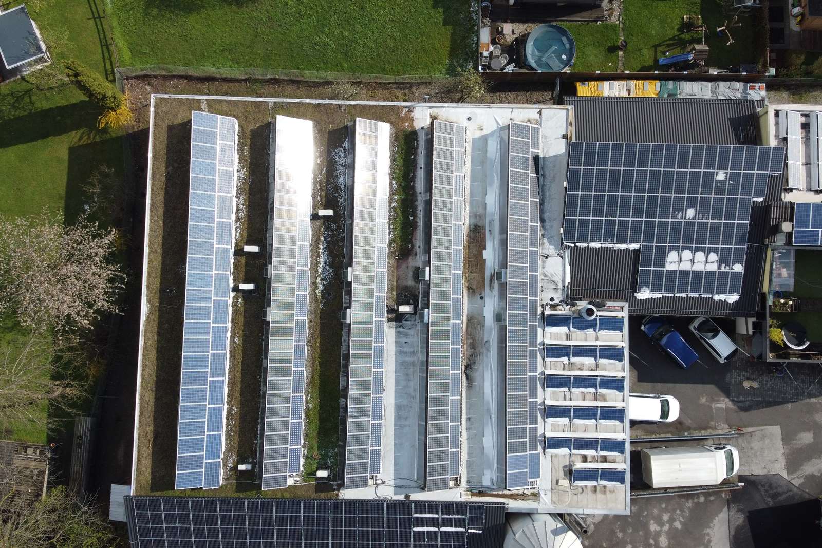 Senkrechtes Luftbild eines Industrieflachdachs, vollständig mit Photovoltaikmodulen belegt